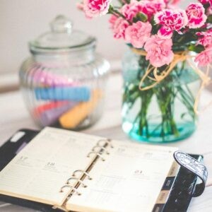 biurko z kwiatami i otwartym organizerem