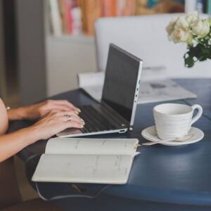 dziewczyna pracująca na laptopie, kawa, notatnik